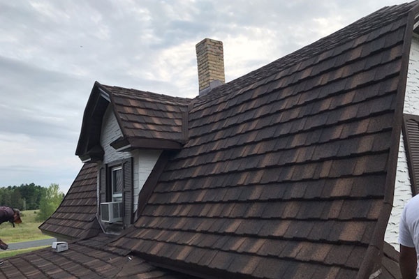 Image of a residential home in Ohio with a newly installed roof. You can see the side view of a residential home with brown shingles.