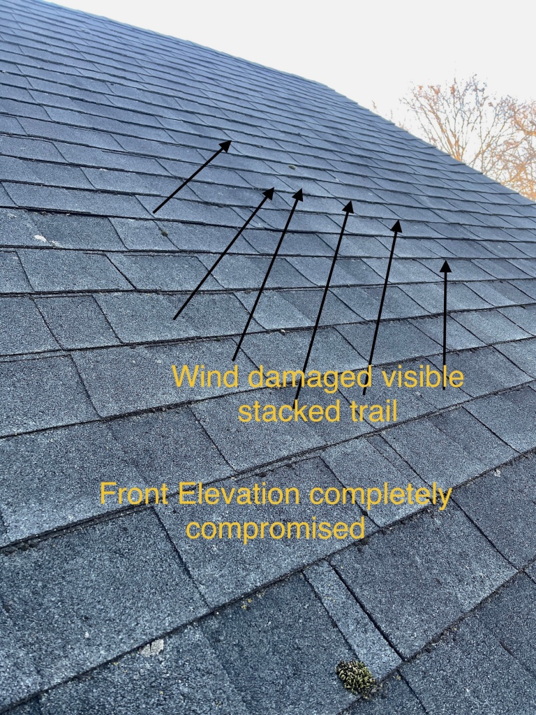 Image showing visible damage due to a wind storm. You can see arrows pointing in the direction of the wind damage across the roof. there are yellow words explaining the direction and where the wind damage is visible on the roof. 